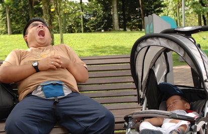 sleepy father in the park with his baby