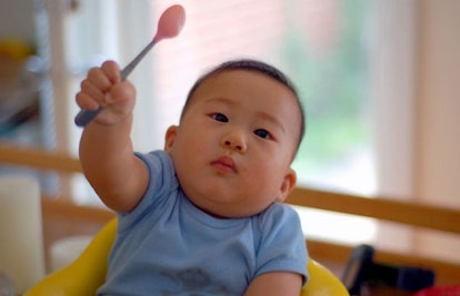 toddler holding up spoon