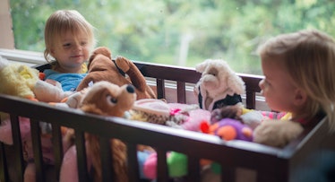 babies in crib full of stuffed animals