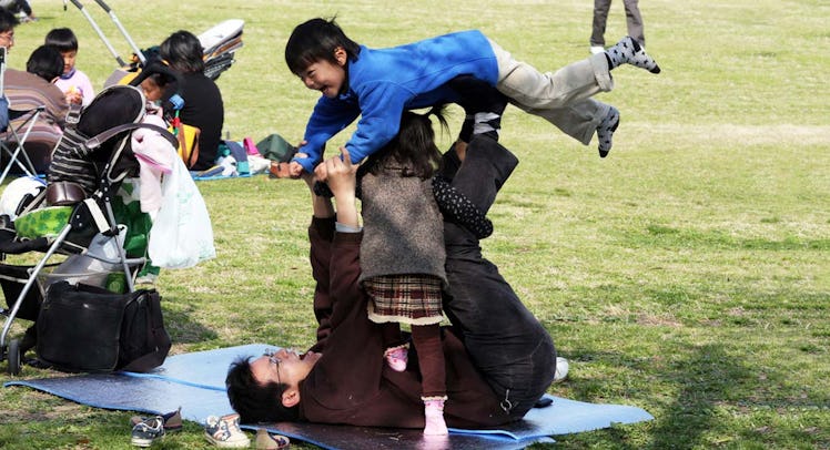 dad playing with children in park