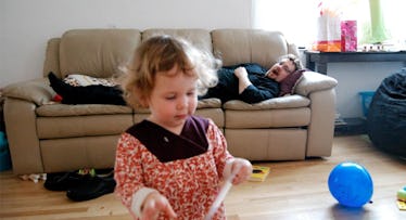 father on couch watching toddler