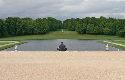 man meditating by a lake