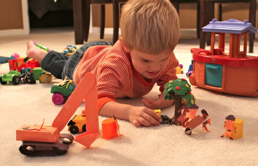 toddler playing with action figures on carpet