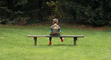 toddler sits alone in bench