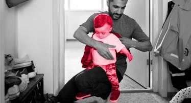 man dressing an infant in baby winter clothes