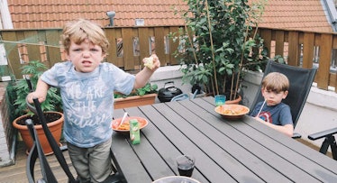 angry toddler eating pasta
