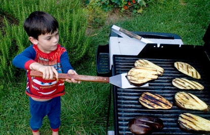 boy grilling eggplant