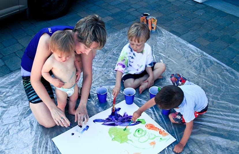 children painting with teacher