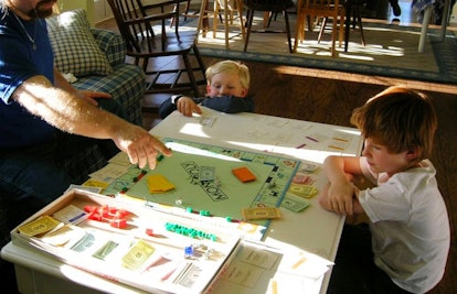 children playing monopoly with dad