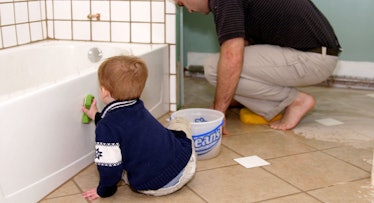 dad and toddler cleaning bathroom