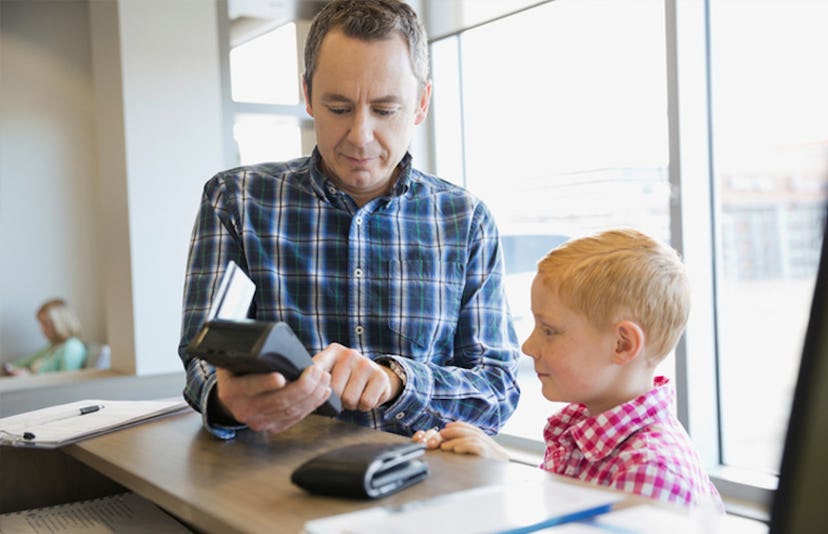 father showing son how to pay with card