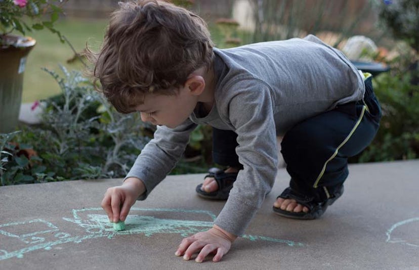 toddler drawing on sidewalk with chalk
