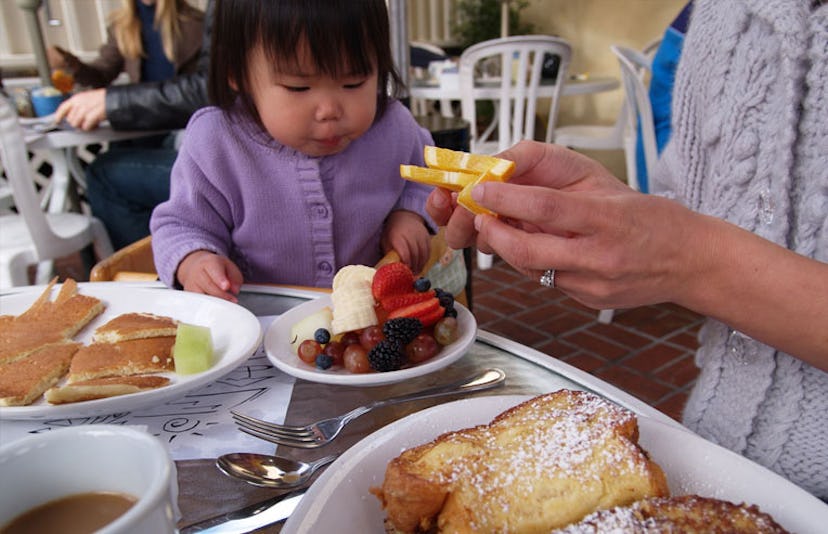 toddler eating breakfast in restaurant