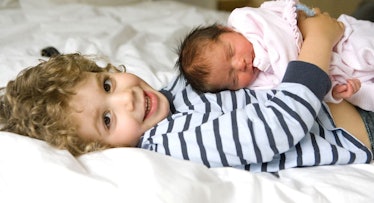 toddler holding newborn sibling