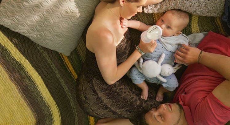 couple feeding baby in bed