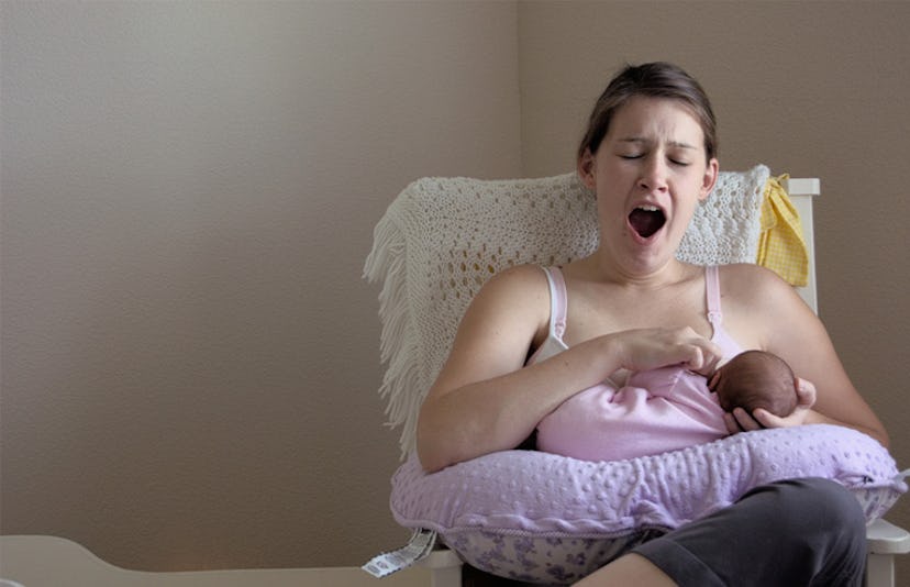 mother yawning while feeding baby