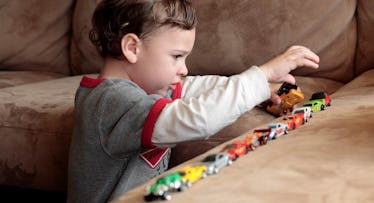 autistic boy plays with cars