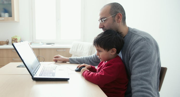 father and son using laptop