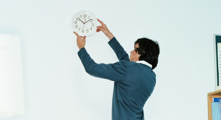 man adjusting clock in office