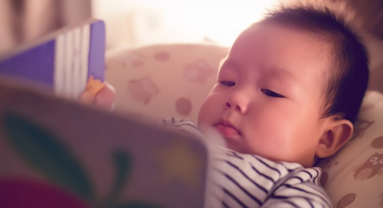 asian baby reading storybook at bedtime