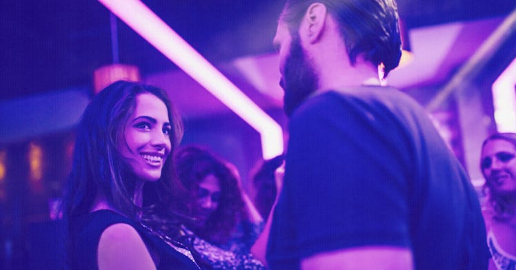 A man and woman talking and smiling at each other in a club