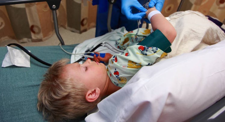Midsection Of Doctor Examining Boy Lying On Bed