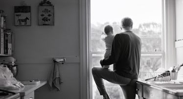 father and baby looking out window