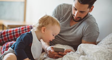 father viewing cellphone with son