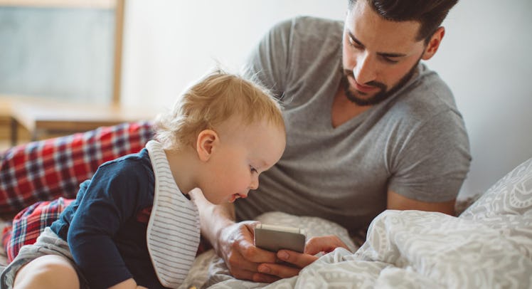 father viewing cellphone with son