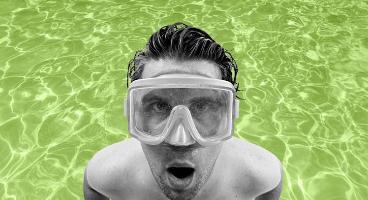 black-and-white photo of a swimmer wearing a diving mask and standing in a neon-green swimming pool