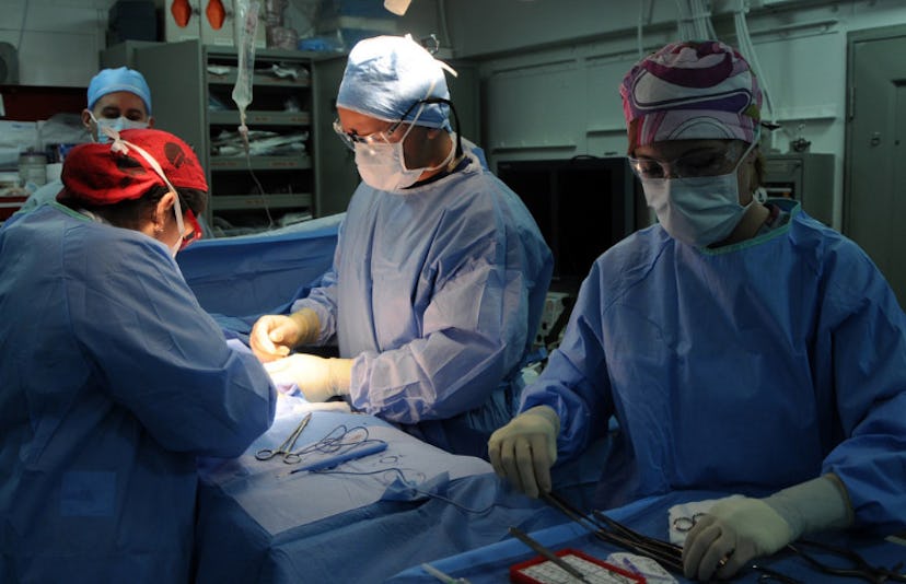 Surgeons performing a laparoscopic surgery on a man's hernia 