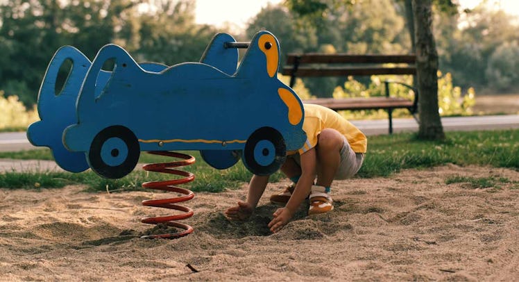 boy playing in playground sand