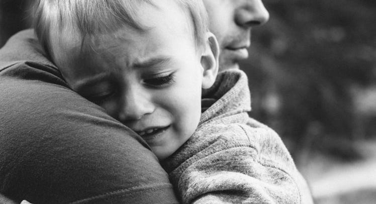 dad hugs crying son