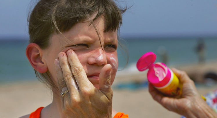 mother putting sunscreen on daughter's face