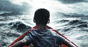 A refugee boy sitting in a red boat in the middle of a thunderstorm over the sea