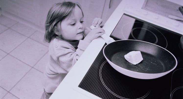 child pulling pan from stovetop