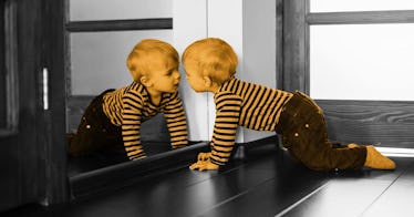 a child looks in a mirror, demonstrating self-awareness