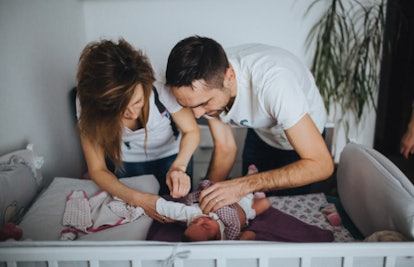 parents changing baby diaper