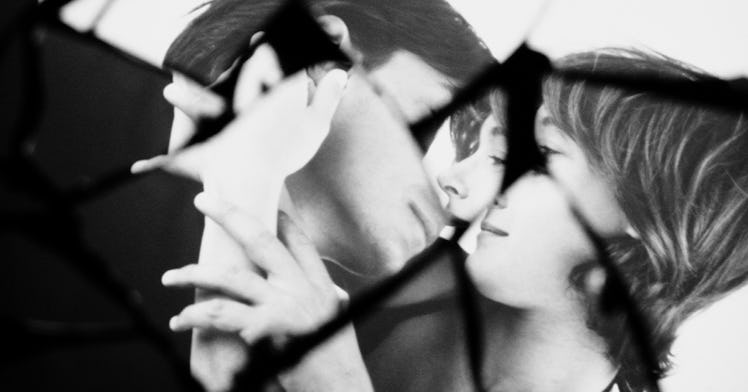 a black white edit of woman and a man kissing