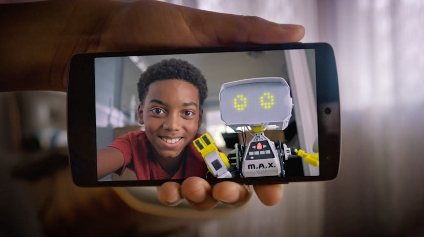 A young boy with his robot on the camera on a phone