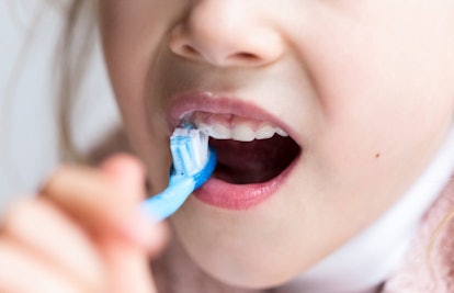 girl brushing teeth closeup