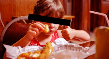 kid eating chicken fingers at restaurant