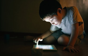 kid using tablet in the dark