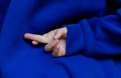 child with crossed fingers behind back