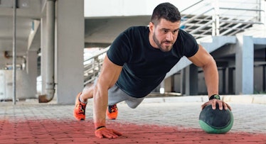 man doing pushup with medicine ball