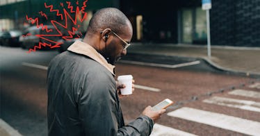 a man stands on the sidewalk and stares down at his smartphone one of the main causes of tech neck