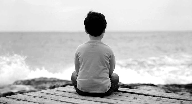 child sitting by the ocean