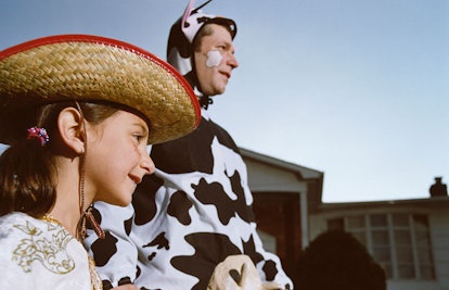 Father and daughter trick or treating, the dad is dressed as a cow while the daughter is a cowgirl
