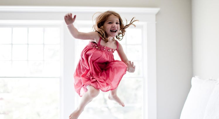 girl jumping in bed