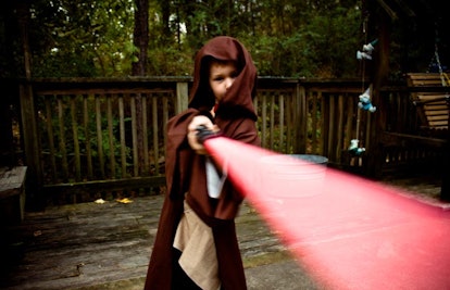 kid playing with lightsaber